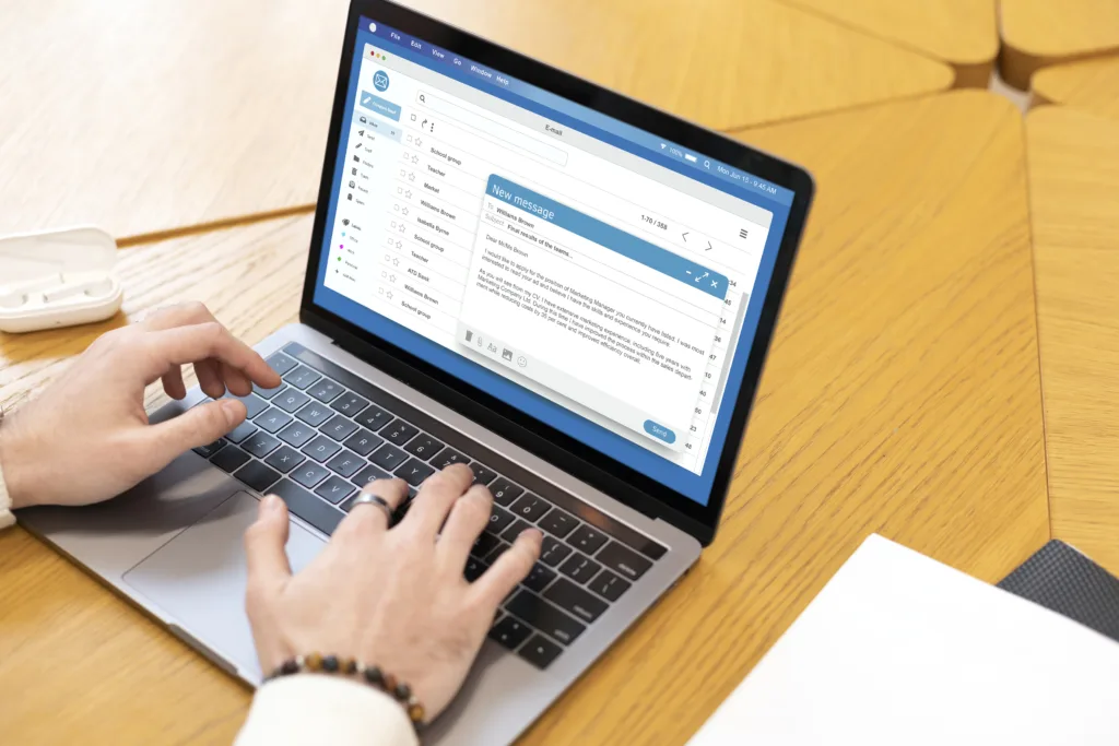Homem utilizando notebook para acessar interface de webmail corporativo em um ambiente de escritório, exemplificando o acesso ao e-mail profissional.